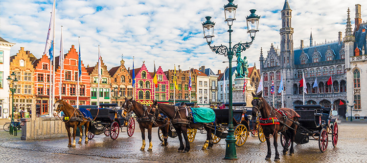 Horse-drawn carriages lined up in the square in Bruges