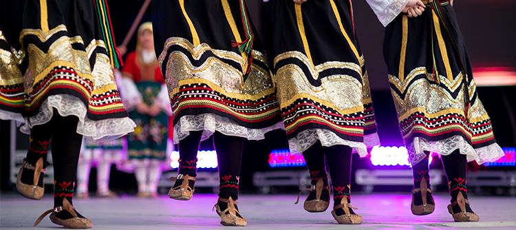 Feet and legs of dancing Bulgarian girls in traditional dresses. 