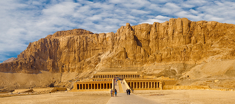 Sun shines on the cliffs and Temple of Hatshepsut in Luxor, Egypt