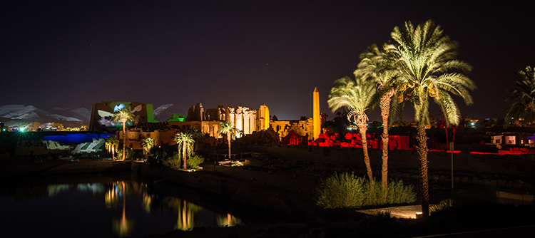 The Temple of Karnak and its palm trees are illuminated for the night.